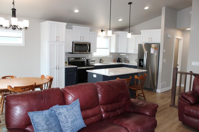 kitchen with visible vents, a sink, stainless steel appliances, light countertops, and open floor plan