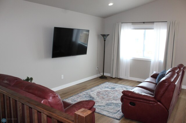 living room featuring recessed lighting, baseboards, wood finished floors, and vaulted ceiling