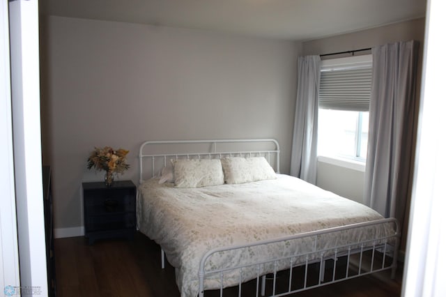 bedroom with baseboards and dark wood finished floors