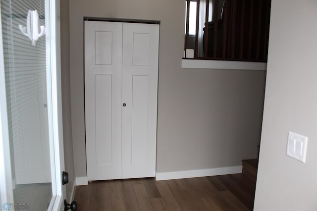 unfurnished bedroom with dark wood-type flooring, baseboards, and a closet