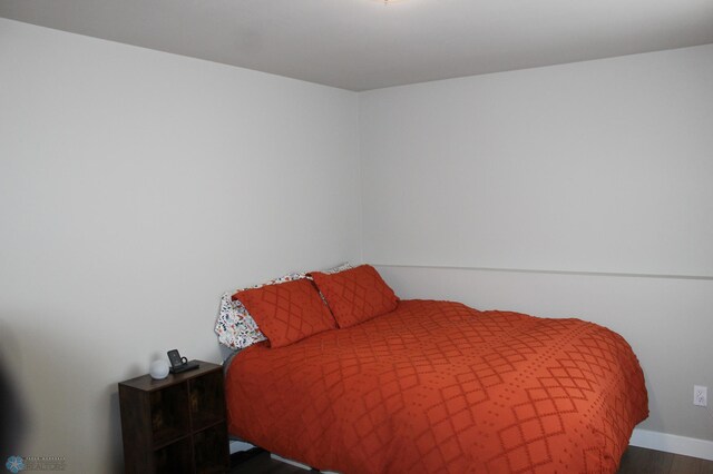 bedroom featuring baseboards and wood finished floors