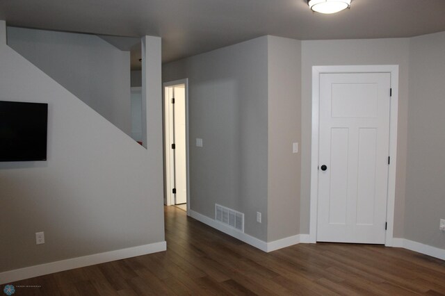 unfurnished room featuring visible vents, baseboards, and wood finished floors