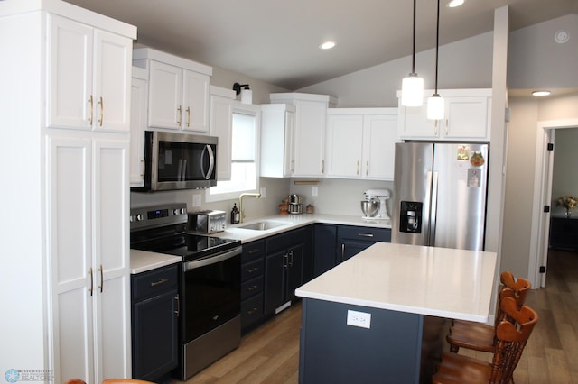 6746 Joseph St, Horace, ND 58047 - kitchen featuring appliances with stainless steel finishes, a sink, white cabinetry, vaulted ceiling, and a kitchen island