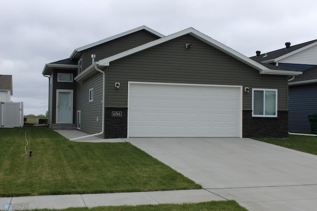 6746 Joseph St, Horace, ND 58047 - ranch-style house featuring driveway, stone siding, a front lawn, and an attached garage