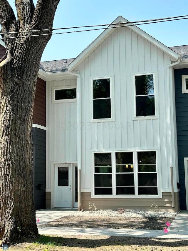 exterior space with roof with shingles and board and batten siding