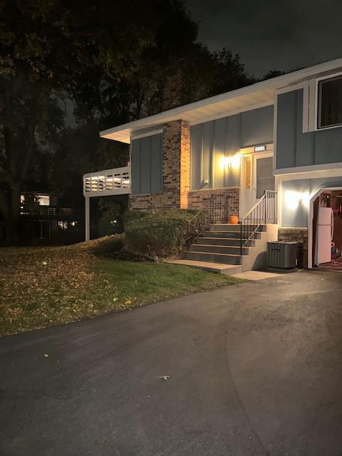 exterior entry at twilight with cooling unit and driveway