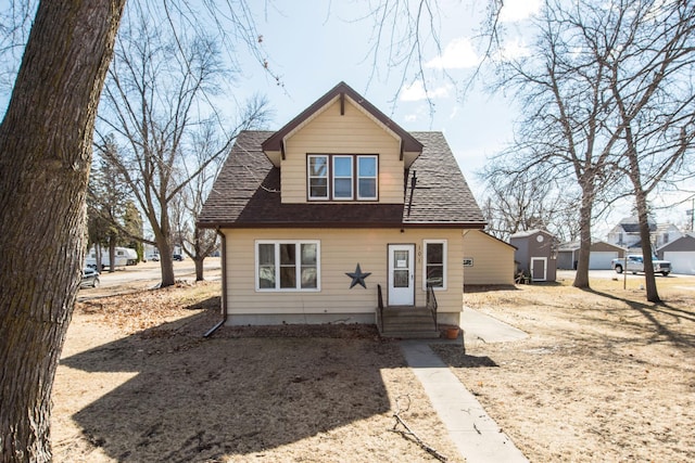 bungalow-style house featuring entry steps and roof with shingles