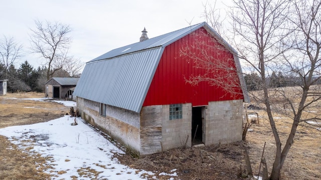 snow covered structure featuring a barn and an outdoor structure