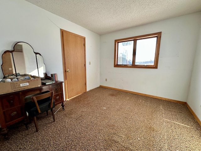 carpeted office featuring baseboards and a textured ceiling