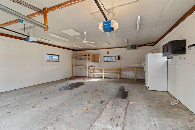 garage with a garage door opener and freestanding refrigerator