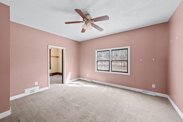 spare room featuring visible vents, carpet floors, baseboards, and ceiling fan