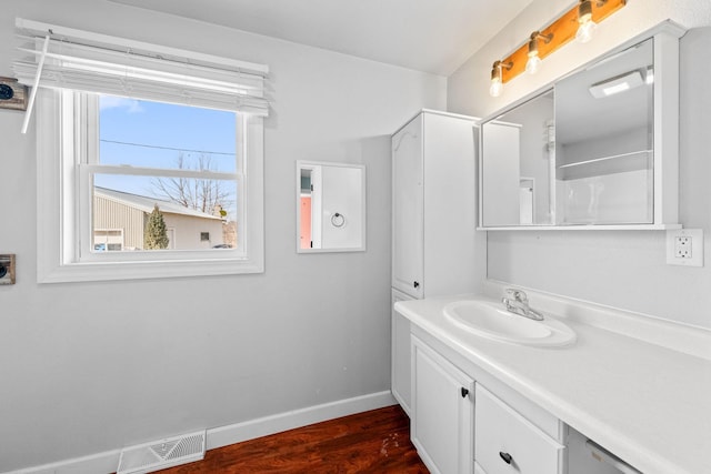 bathroom featuring visible vents, vanity, baseboards, and wood finished floors