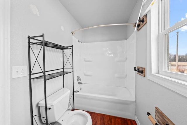 bathroom featuring toilet, shower / bathtub combination, and wood finished floors