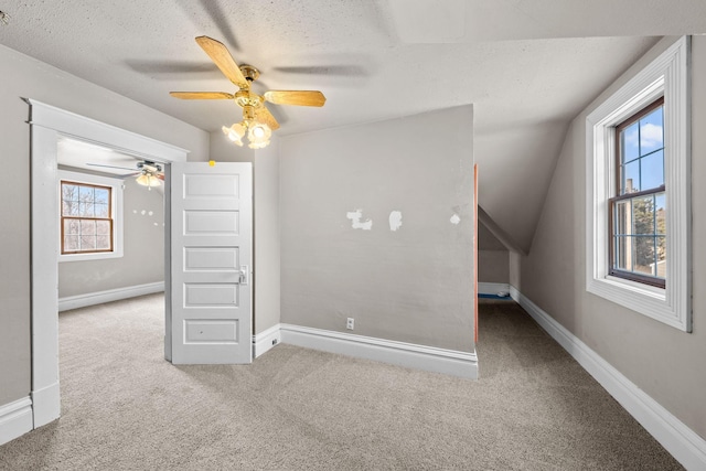 unfurnished bedroom with ceiling fan, a textured ceiling, baseboards, and carpet floors