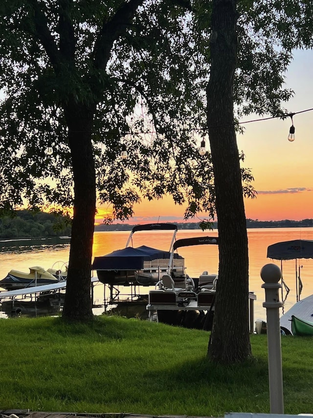 dock area featuring a lawn and a water view