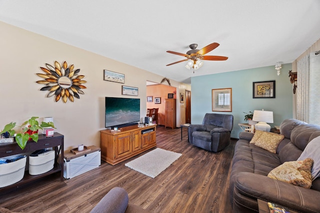 living room featuring dark wood-type flooring and ceiling fan