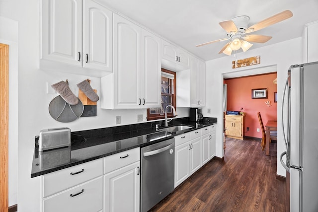 kitchen with dark wood finished floors, white cabinets, appliances with stainless steel finishes, and a sink