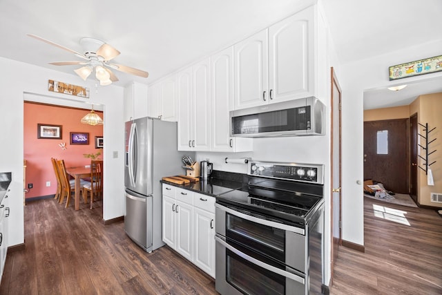 kitchen with dark wood finished floors, white cabinets, and appliances with stainless steel finishes