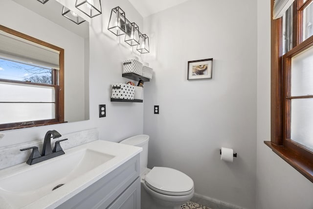 half bath featuring baseboards, toilet, and vanity