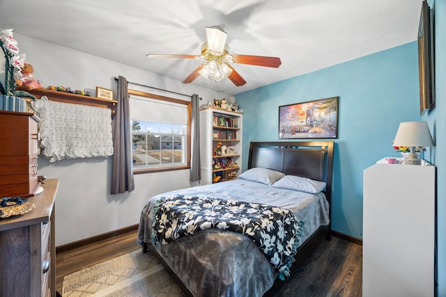 bedroom with a ceiling fan, wood finished floors, and baseboards