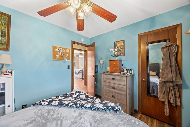 bedroom with baseboards, ceiling fan, and wood finished floors