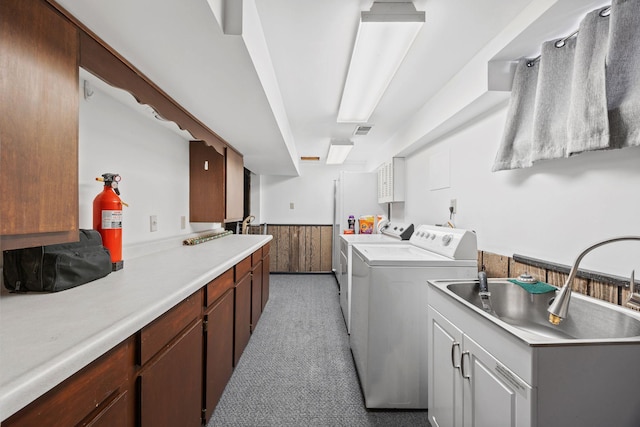 clothes washing area featuring a wainscoted wall, visible vents, washer and dryer, cabinet space, and wooden walls