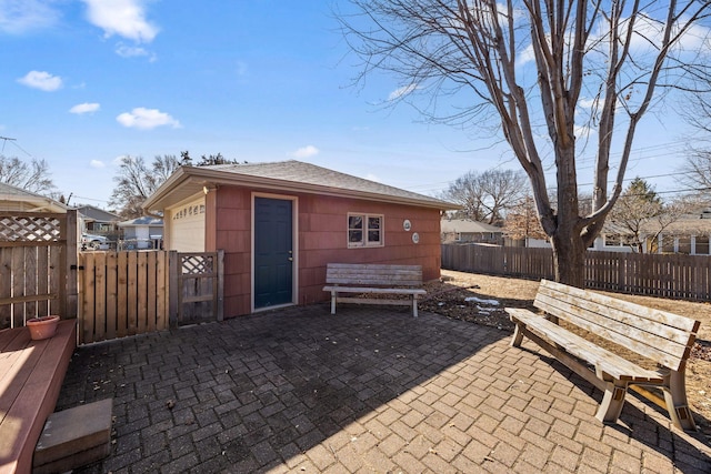 view of patio with an outbuilding, fence private yard, and a gate