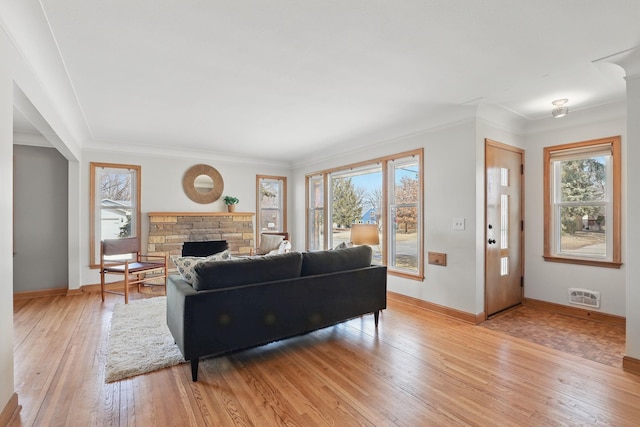 living room with plenty of natural light, a fireplace, light wood-type flooring, and baseboards