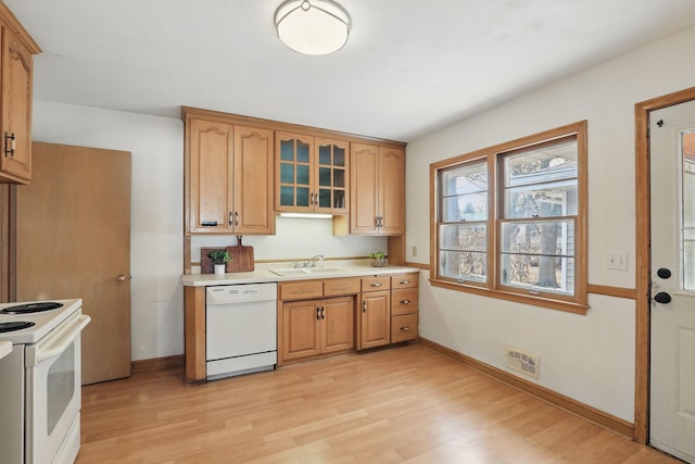 kitchen featuring white appliances, visible vents, light countertops, glass insert cabinets, and light wood-type flooring