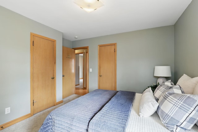 bedroom with light carpet and baseboards