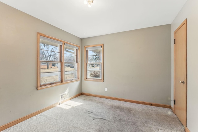 spare room with baseboards and light carpet