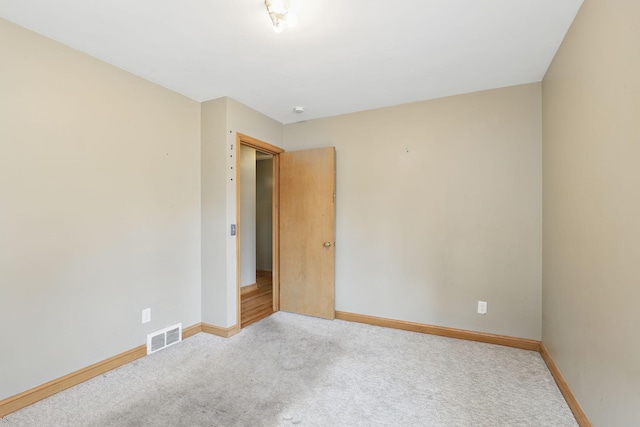 carpeted empty room featuring visible vents and baseboards