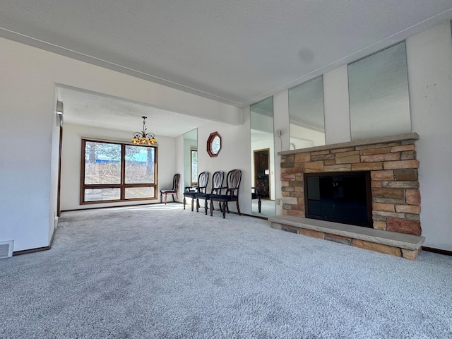 unfurnished living room with visible vents, baseboards, a chandelier, carpet flooring, and a textured ceiling