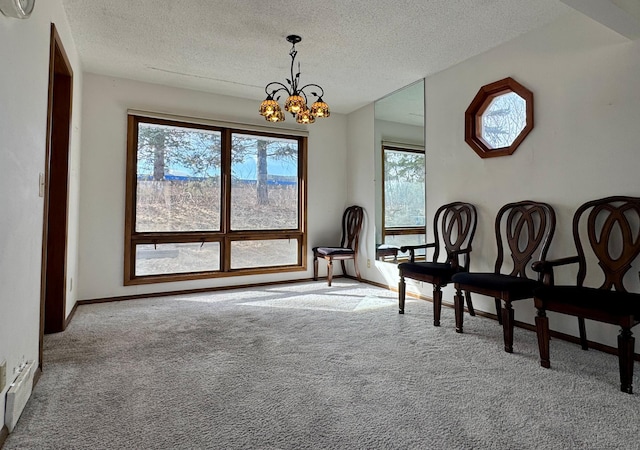 sitting room with baseboards, an inviting chandelier, a textured ceiling, and carpet