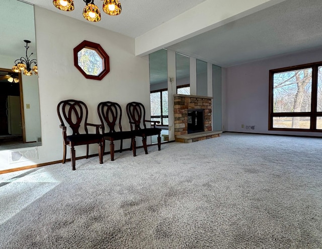 carpeted living area featuring a stone fireplace, a textured ceiling, and baseboards