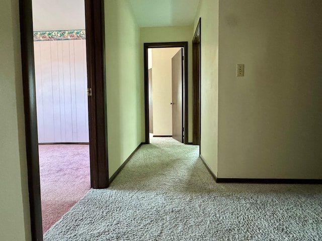 corridor with baseboards and carpet