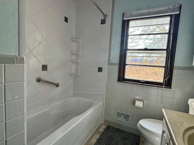 full bathroom with a healthy amount of sunlight, vanity, tile walls, and toilet