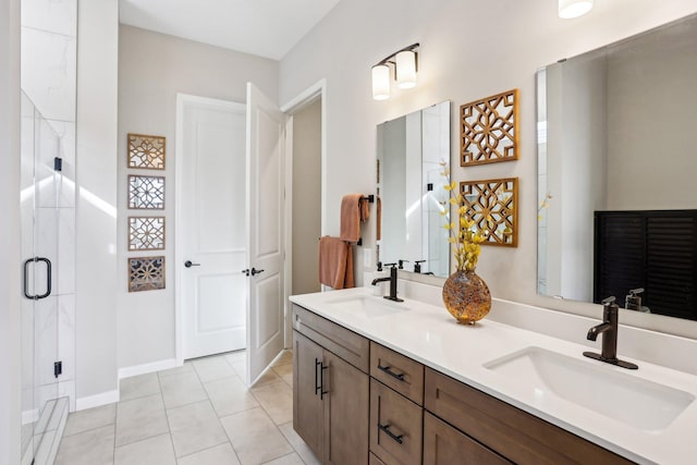 bathroom with double vanity, a shower stall, tile patterned floors, and a sink
