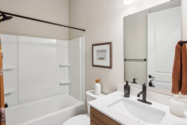 bathroom featuring toilet, vanity, and bathing tub / shower combination
