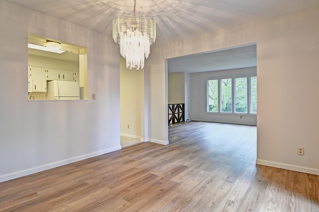 21414 Tulip St NW, Oak Grove, MN 55303 - unfurnished room with a chandelier and wood finished floors