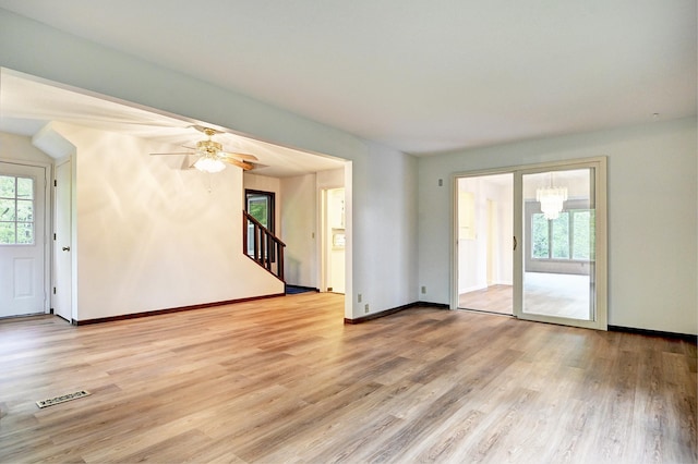21414 Tulip St NW, Oak Grove, MN 55303 - unfurnished room with light wood-style flooring, stairs, a chandelier, and ceiling fan