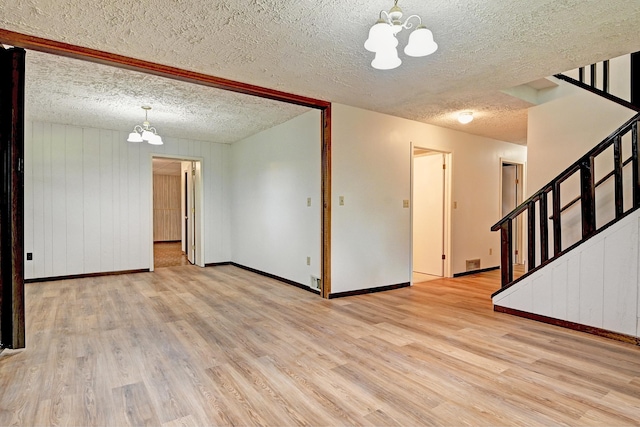 21414 Tulip St NW, Oak Grove, MN 55303 - spare room featuring a chandelier, light wood finished floors, stairs, and a textured ceiling