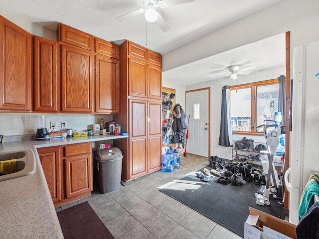 kitchen featuring a ceiling fan and brown cabinets