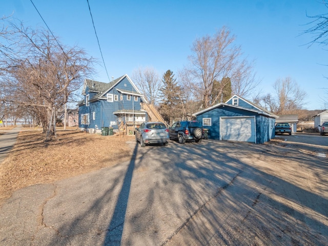 view of property exterior with an outbuilding, driveway, and a detached garage