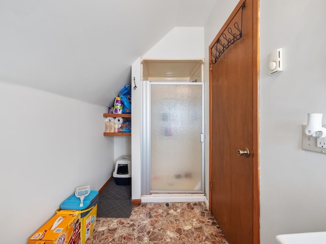 bathroom featuring a shower stall and vaulted ceiling