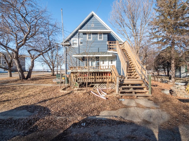 back of house featuring stairway and a wooden deck