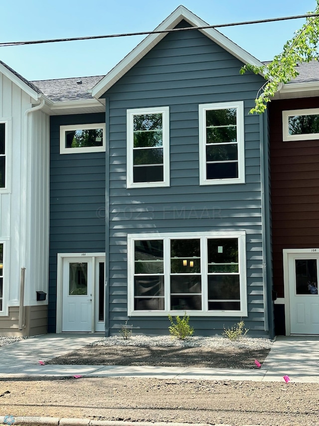 view of front facade featuring board and batten siding and roof with shingles