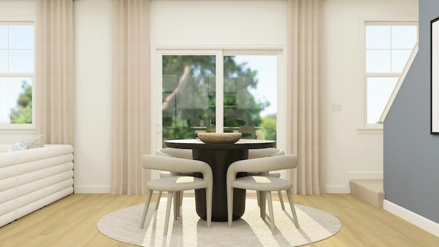 dining area with baseboards and wood finished floors