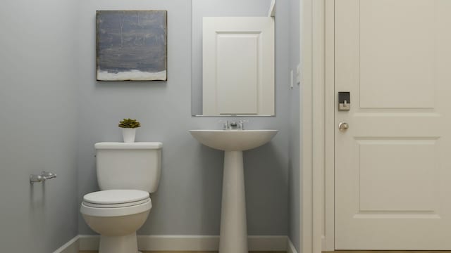 bathroom featuring toilet and baseboards