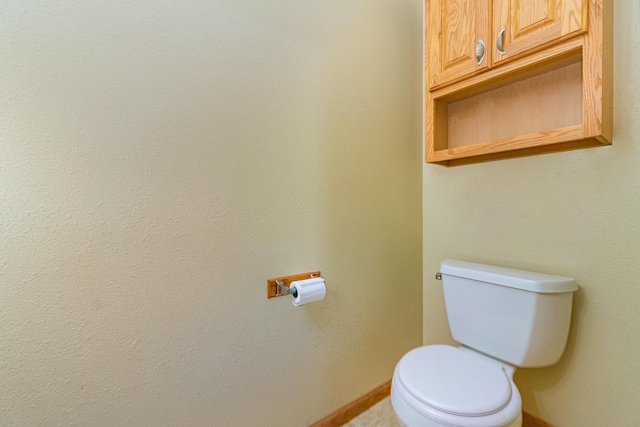 bathroom with toilet and baseboards